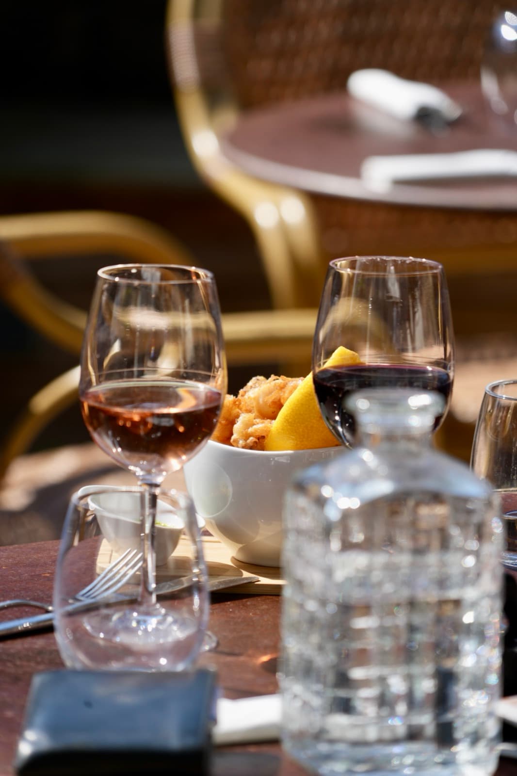 L'apéro : verres de vin, carafe et beignets à partager